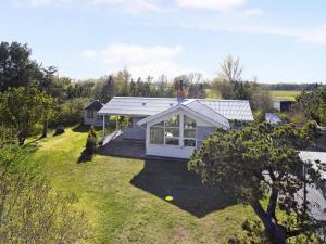 a small white house in a field with a yard at Holiday Home Frido - 500m from the sea by Interhome in Sæby