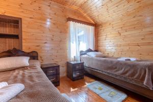 a bedroom with two beds in a log cabin at Cottage "Labskaldi-Laila" 