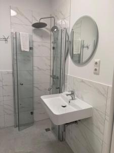 a white bathroom with a sink and a shower at Pension Marie Prenzlauer Berg in Berlin +35 photos