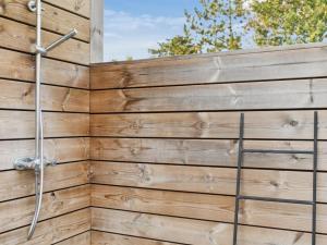 a wooden fence with a shower at Holiday Home Elmeri - 200m from the sea by Interhome in Ebeltoft