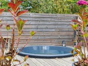 a hot tub in front of a wooden wall at Holiday Home Elmeri - 200m from the sea by Interhome in Ebeltoft +28 photos