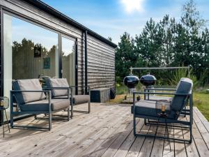 a patio with two chairs on a wooden deck at Holiday Home Jale - 900m from the sea by Interhome in Marielyst +25 photos
