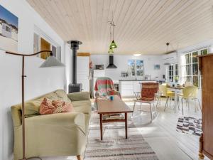 a living room with a couch and a table at Holiday Home Aleta - 300m from the sea by Interhome in Fakse Ladeplads