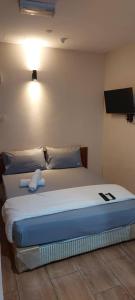 a bed in a room with a tv on the wall at NEW TOWN HOTEL Puchong in Kampong Kuchai