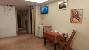 a room with a table and a television on a wall at NEW TOWN HOTEL Puchong in Kampong Kuchai