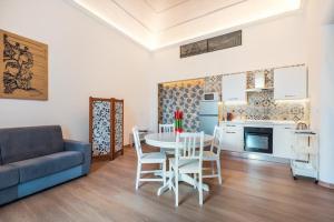 a living room with a table and chairs and a kitchen at Dimore Donna Serafina in Catania +26 photos