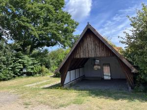 a small barn with a door in a field at Holiday Home Skyler - 250m from the sea by Interhome in Gudhjem