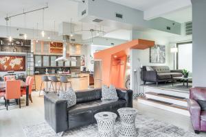 a living room with a couch and a kitchen at Dtwn Cleveland Loft-Style Condo Walk to Stadiums! in Cleveland