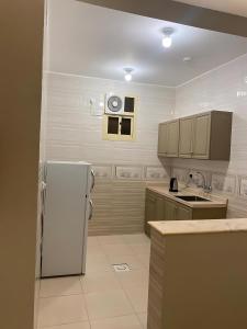 a kitchen with a white refrigerator and a microwave at شقق جوهرة الخميس للشقق المخدومة in Khamis Mushayt