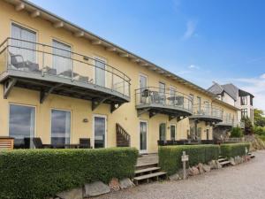 a large yellow building with balconies and bushes at Apartment Franca - 75m from the sea by Interhome in Allinge