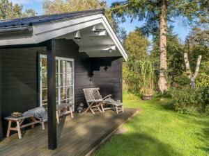a patio with two chairs on a deck at Holiday Home Evi - 500m from the sea by Interhome in Jerup +16 photos