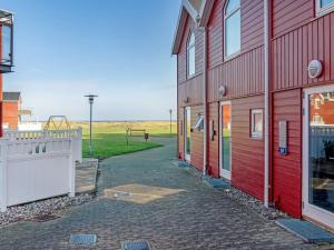Una hilera de edificios rojos con un parque infantil al fondo en Apartment Vincent - from the sea by Interhome, en Hadsund 17 fotos más