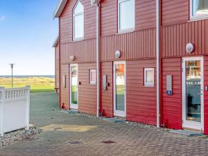 un edificio rojo con puertas blancas. en Apartment Vincent - from the sea by Interhome, en Hadsund