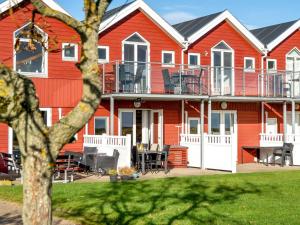 Una casa roja con una mesa y sillas delante de ella. en Apartment Vincent - from the sea by Interhome, en Hadsund