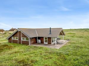 a house with a deck in the middle of a field at Holiday Home Märta - 250m from the sea by Interhome in Lemvig