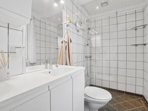 a white bathroom with a toilet and a sink at Holiday Home Caren - 75m from the sea by Interhome in Allinge +22 photos