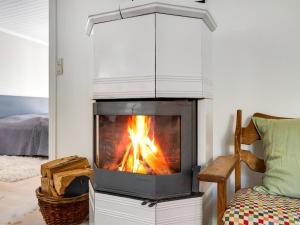a fireplace in a living room with a fire in it at Holiday Home Thermund - 5m from the sea by Interhome in Knebel +29 photos