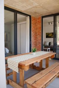 乔治209 Le Jardin George的房间里有一张木制野餐桌，墙上有砖墙 更多9张照片