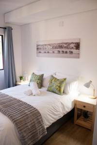 乔治209 Le Jardin George的卧室里有一张床，床单和枕头都是白色的