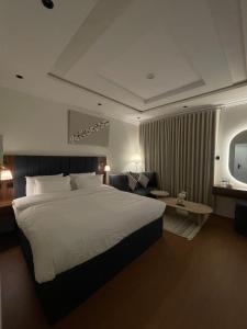 a hotel room with a large bed and a couch at Modern Studio in Al Malqa Riyadh Near to KAFD-Blvd in Riyadh