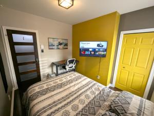 a bedroom with a bed and a flat screen tv at The Modern Stays in Montréal