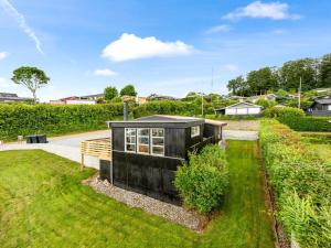 a black tiny house in the middle of a yard at Holiday Home Filomena - 300m from the sea by Interhome in Aabenraa