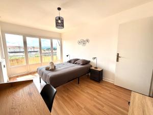 a bedroom with a bed with a cat sitting on it at Le Valentine, Calme & Lumineux, proche centre in Valence