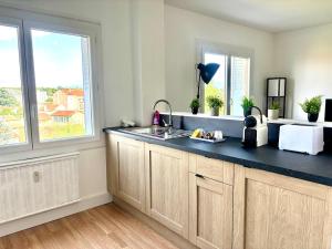 a kitchen with a blue counter top and two windows at Le Valentine, Calme & Lumineux, proche centre in Valence +20 photos