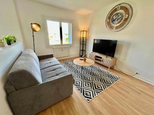a living room with a couch and a flat screen tv at Le Valentine, Calme & Lumineux, proche centre in Valence