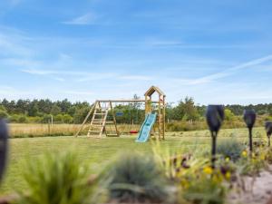 a playground with a slide in a field at Holiday Home Sönke - 4km from the sea by Interhome in Tagholm