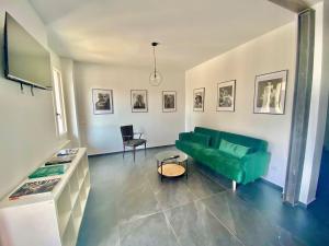 a living room with a green couch and a table at Di Vittorio Open Space - CasaMellini in Rivoltella