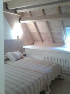 1 dormitorio con cama blanca y ventana en Casa de los Beneficiados, en Roncesvalles