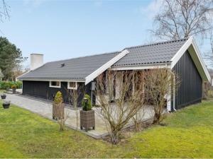ein schwarzes Haus mit schwarzem Dach in der Unterkunft Holiday Home Frithlef - 1-3km from the sea by Interhome in Græsted