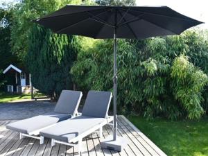 zwei Stühle und ein Sonnenschirm auf einer Terrasse in der Unterkunft Holiday Home Frithlef - 1-3km from the sea by Interhome in Græsted + 15 Fotos