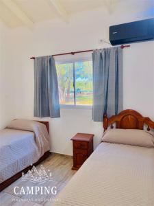 a bedroom with two beds and a window at Cabañas Camping Malvinas Argentinas Paso de la Patria in Paso de la Patria +19 photos