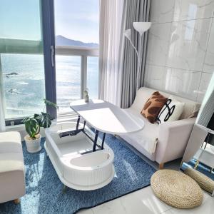 a living room with a table and a couch at 광안리 T-OCEAN House in Kwangan-dong