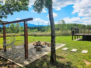 a picnic table and a bench next to a tree at Chalet Tomina Koliba Lika by Interhome in Lovinac