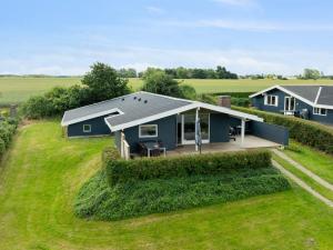 une vue de tête sur une maison bleue sur un champ vert dans l'établissement Holiday Home Nelina - 300m from the sea by Interhome, à Bogense