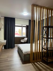 Una habitación de hotel con una cama y una ventana. en Little Comfort Home, en Karakol