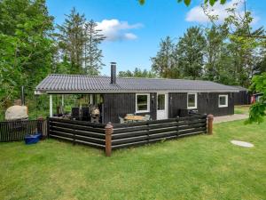 a black and white house with a fence at Holiday Home Tiina - 500m to the fjord by Interhome in Tarm