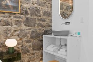 a bathroom with a sink and a stone wall at Le Chateau de Pierre in Quebec City +171 photos
