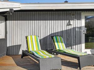 due sedie sedute su un ponte accanto a una casa di Holiday Home Kajsa - 250m from the sea by Interhome a Svendborg