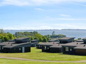 a row of houses with a lake in the background at Holiday Home Magga - 520m from the sea by Interhome in Bogentved