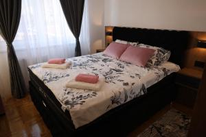 a bedroom with a bed with two pillows on it at Delux apartments in Gornji Milanovac