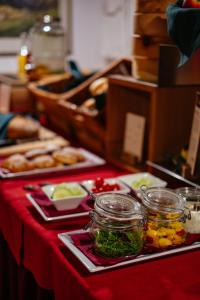 a table with jars of food on a red table at Alpen Gasthof Apartments Hohe Burg in Trins +116 photos