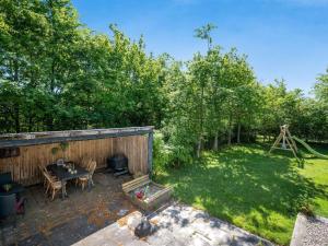 a backyard with a table and chairs and a grill at Holiday Home Landolf - 800m from the sea by Interhome in Blåvand