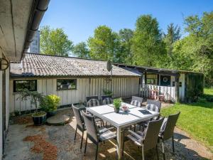 a patio with a table and chairs in front of a house at Holiday Home Landolf - 800m from the sea by Interhome in Blåvand +18 photos