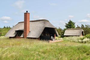 an old house with a thatched roof in a field at 20039-Ulfborg-Sortebaervej-8 in Vedersø Klit