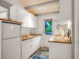 eine Küche mit weißen Schränken und einem Kühlschrank in der Unterkunft Holiday Home Amaya - 1km from the sea by Interhome in Blåvand + 14 Fotos