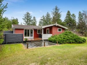 ein rotes Haus mit einem Hof in der Unterkunft Holiday Home Amaya - 1km from the sea by Interhome in Blåvand